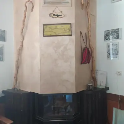a corner of a room with a fireplace at Therisso Rooms in Thérison