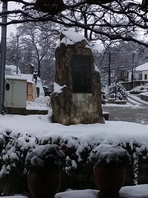 a statue in a yard covered in snow at Therisso Rooms in Thérison