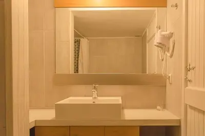 a bathroom with a sink and a mirror at Kalypso Studios & Rooms in Palaiochóra
