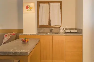 a kitchen with a sink and a counter with a bowl of fruit at Kalypso Studios & Rooms in Palaiochóra