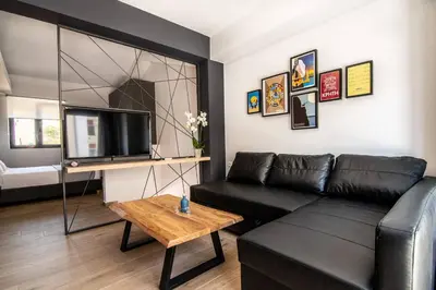 a living room with a black leather couch and a table at MOS Luxury City Suites - The Loft in Chania Town