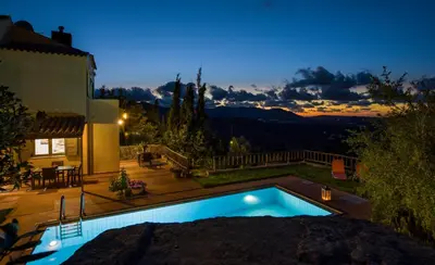 a swimming pool in the backyard of a house at night at Malathiros Traditional Villas in Maláthiros