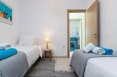 a bedroom with two beds and a bathroom at Villa PENELOPE in Galatás
