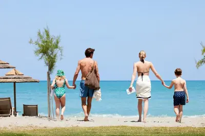 a family walking on the beach at Euphoria Resort - All Inclusive in Kolymvari