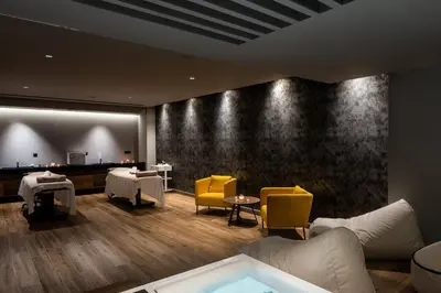 a waiting room with yellow chairs and a bath tub at Euphoria Resort - All Inclusive in Kolymvari