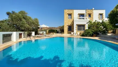 a large blue swimming pool in front of a house at Villa 