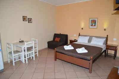 a bedroom with a bed and a table and a chair at Melia Studios in Kato Daratso