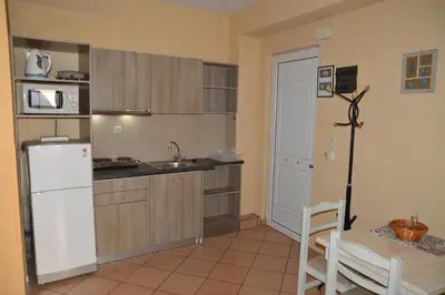 a kitchen with a white refrigerator and a table at Melia Studios in Kato Daratso
