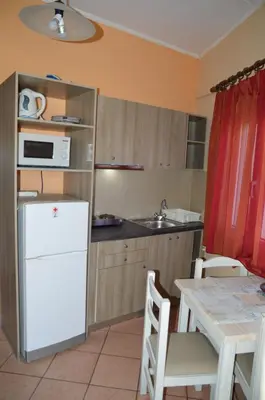 a kitchen with a white refrigerator and a table at Melia Studios in Kato Daratso