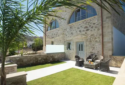 a stone building with chairs and a whiteboard at Kamartsos Villa 3 in Áyios Yeóryios