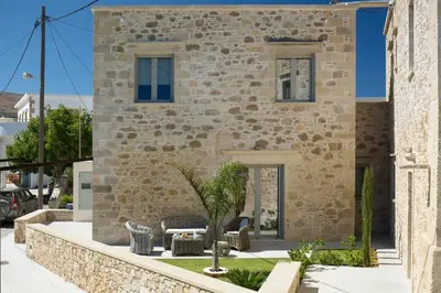 a stone house with a garden in front of it at Kamartos Villa 1 in Áyios Yeóryios