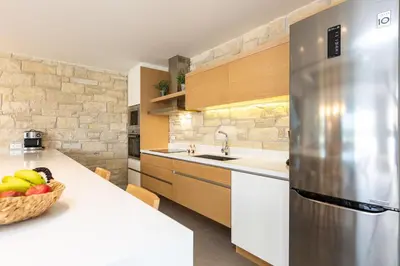 a kitchen with a stainless steel refrigerator and a bowl of fruit at Sissy Luxury Villa Chania in Plataniás