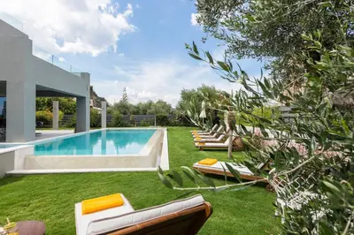 a backyard with a swimming pool and lounge chairs at Sissy Luxury Villa Chania in Plataniás