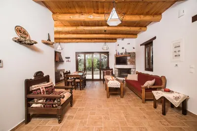 a large living room with wooden ceilings and furniture at ARADENA TRADITIONAL House 4 in Arádhaina