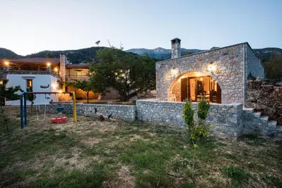 a stone house with a stone wall in a yard at ARADENA TRADITIONAL House 4 in Arádhaina