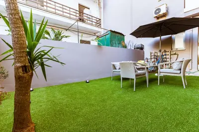 a patio with a table and chairs on grass at Lazaretta studio in Chania Town