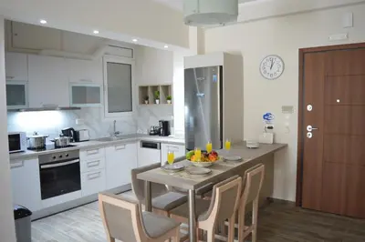 a kitchen with a table with a bowl of fruit on it at Botonis Bright Spacious Apartment in Chania Town