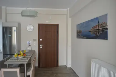 a kitchen with a table and a wooden door at Botonis Bright Spacious Apartment in Chania Town