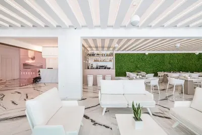 a restaurant with white furniture and a green wall at Lagon Life Spirit Boutique Hotel - Adults Only in Chania Town