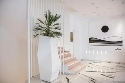 a staircase with a plant in a white hallway at Lagon Life Spirit Boutique Hotel - Adults Only in Chania Town