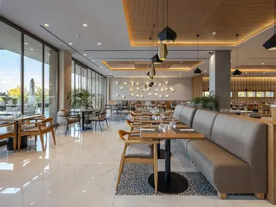 a restaurant with wooden tables and chairs and windows at Myrion Beach Resort & Spa - Adults Only in Gerani Chanion