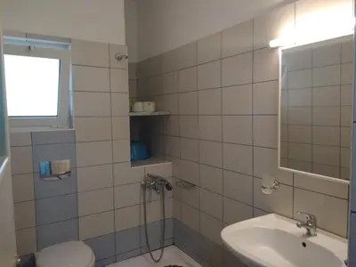 a bathroom with a sink and a toilet and a mirror at Paleochora Elizabeth Apartments in Palaiochóra