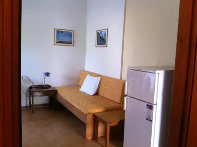 a living room with a couch and a refrigerator at Paleochora Elizabeth Apartments in Palaiochóra