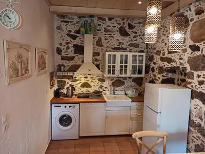 a kitchen with a refrigerator and a washer and dryer at Polios in Avdhoulianá