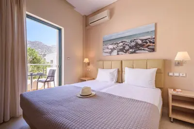 a hotel room with a bed with a hat on it at Hotel Poseidon in Palaiochóra