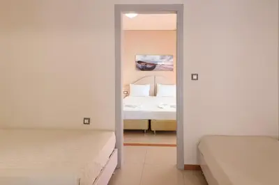 a bedroom with two beds and a mirror at Hotel Poseidon in Palaiochóra