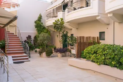 a courtyard of a building with stairs and plants at Hotel Poseidon in Palaiochóra