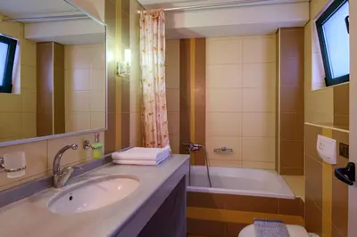 a bathroom with a sink and a tub at Hotel Poseidon in Palaiochóra