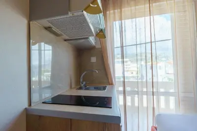 a kitchen with a sink and a large window at Nikos Rooms in Palaiochóra