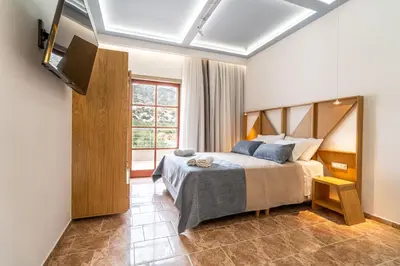 a bedroom with a bed and a large window at Manos Studios in Palaiochóra