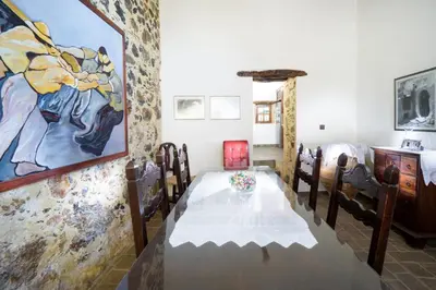 a dining room with a table and a painting on the wall at Villa Talos in Palaiochóra