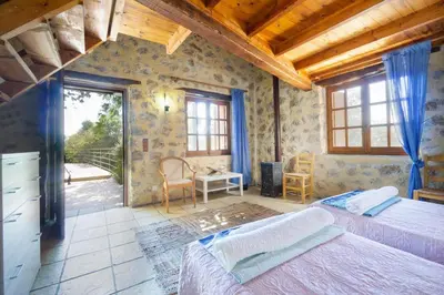a bedroom with two beds and a table and chairs at Villa Talos in Palaiochóra
