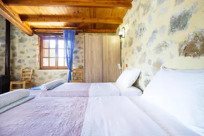 a bedroom with two beds and a window at Villa Talos in Palaiochóra