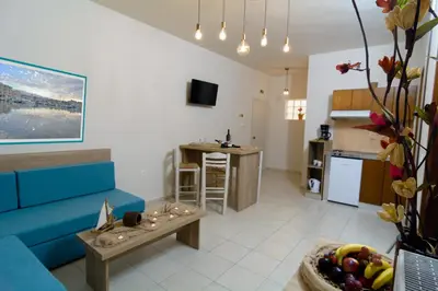 a living room with a blue couch and a table at Kosmos A.G.K Studios-Apts in Kato Daratso