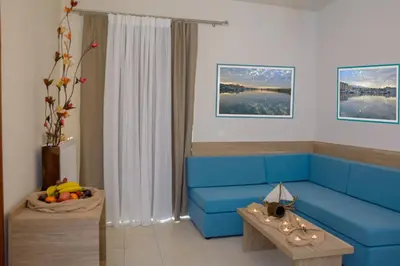 a living room with a blue couch and a table at Kosmos A.G.K Studios-Apts in Kato Daratso