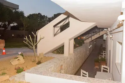 a house with a stone wall and a staircase at Kosmos A.G.K Studios-Apts in Kato Daratso