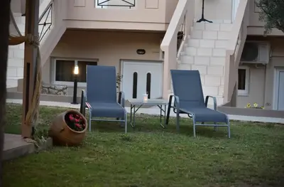 two blue chairs and a table in a yard at Kosmos A.G.K Studios-Apts in Kato Daratso