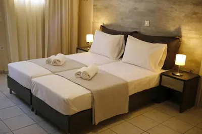 a bedroom with a large bed with towels on it at Kosmos A.G.K Studios-Apts in Kato Daratso