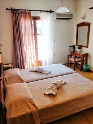 a bedroom with a bed with a towel on it at Alexandra Hotel in Kalamaki Chanion
