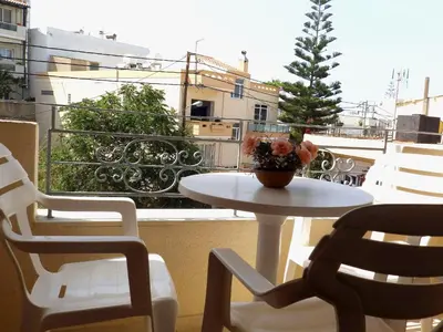 a table and chairs on a balcony with a christmas tree at Alexandra Hotel in Kalamaki Chanion