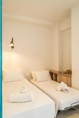 two beds in a room with white sheets at Livikon by the Sea in Khóra Sfakíon