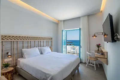 a bedroom with a bed and a view of the ocean at Livikon by the Sea in Khóra Sfakíon