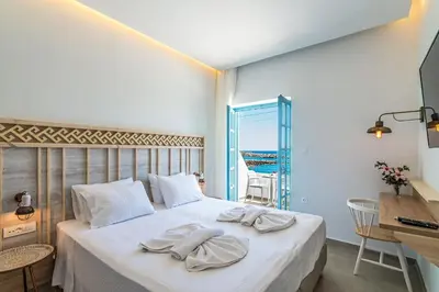 a bedroom with a bed with towels on it at Livikon by the Sea in Khóra Sfakíon