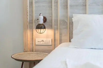 a bedroom with a bed and a lamp and a table at Livikon by the Sea in Khóra Sfakíon