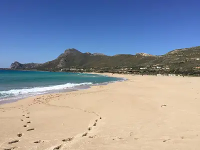 a beach with footprints in the sand and the ocean at Falassarna Beach studios&apartments in Falasarna