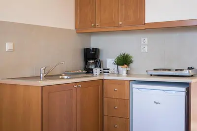 a kitchen with wooden cabinets and a sink at Hermes Sea View in Stalos